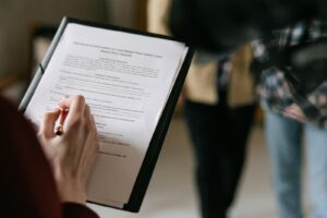 Un couple examine les documents immobiliers à l'intérieur en mettant l'accent sur l'écriture et la discussion.