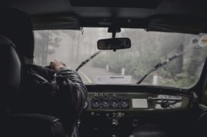 homme conduisant une voiture pendant une journée pluvieuse