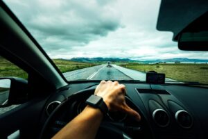 personne conduisant une voiture près d'un véhicule sous des nuages ​​nimbus
